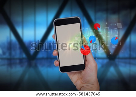 Hand holding mobile phone against white background against room with large window looking on city