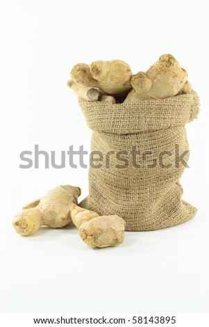 Still picture of Ginger roots in burlap bag over white background.