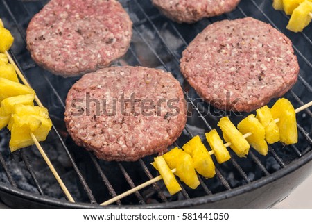 Burger meat with pineapple on a grill.