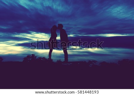 Silhouette Romantic couple in love ,man and women hold hands in nature ,sky with cloud in sunset time,background blurred effect