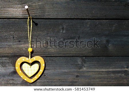 orange wooden heart hanging on a nail on a wooden wall/hearts fitting in each other/love you