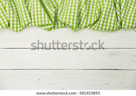 Green crumbled tablecloth on white table background.
