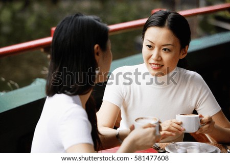 Women in cafe, cups in hand