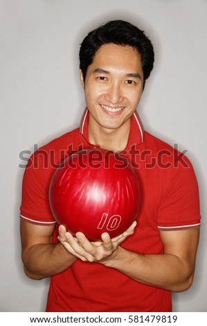 Man looking at camera, holding bowling ball