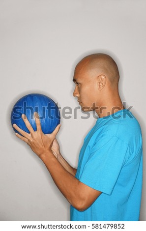 Man holding bowling ball looking away