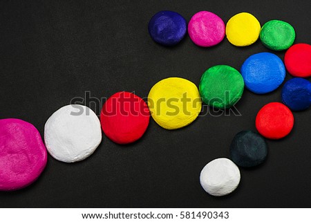 Colorful, bright, beautiful, different sized circles on the dark surface of the table