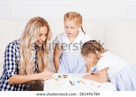 Mother with two beautiful daughters are drawing. Family, motherhood concept. 