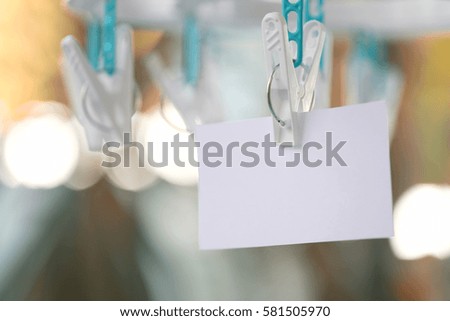 white paper notes hanging in a clothesline on green bokeh background.