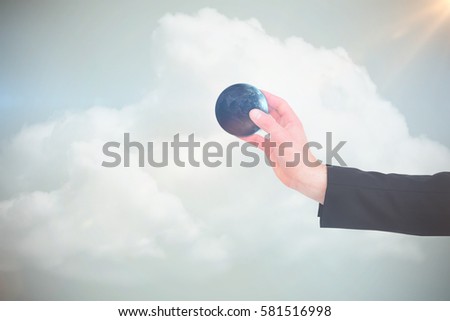 Businessman in suit holding his hand out against grey