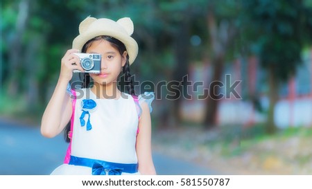 Little girl  photographer with camera. The concept strengthens the imagination of children.
