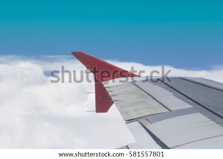 Wing of an airplane flying above the city. The view from an airplane window. Cloudy and color sky. Photo applied to tourism operators. picture for add text message or frame website. Traveling concept.