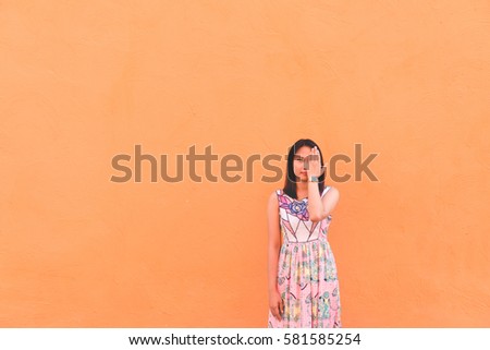 Portrait of beautiful asian woman pose on orange wall,lifestyle of single girl