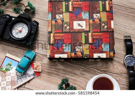 Memory set of vintage things such old photo album, postcards, alarm clock in shape of camera, watch, retro postcards and cup of coffee on wooden background. Top view. Flat lay.