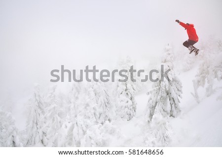 Man in red jump to the snow in winter landscape