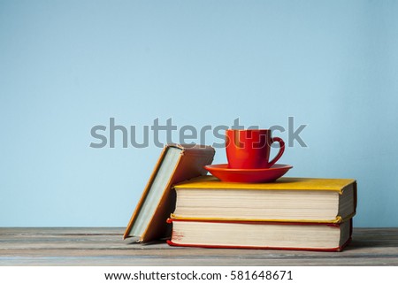 Stack of books on wooden table with a cup of tea. Education background. Back to school. Copy space for text.