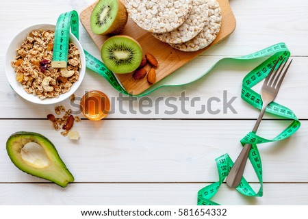 Concept diet - healthy food with muesli, honey, kiwi and cereals Royalty-Free Stock Photo #581654332