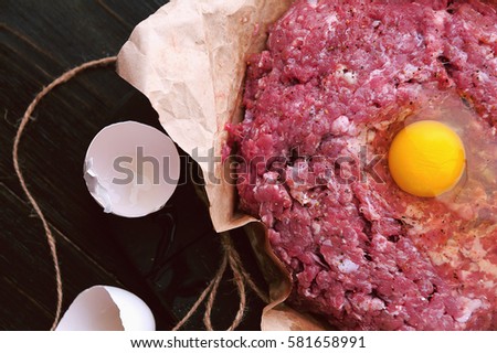ground beef in a paper bag with a raw egg