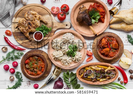 A lot of food on the wooden table. Georgian cuisine. Top view. Flat lay . Khinkali and Georgian dishes Royalty-Free Stock Photo #581659471