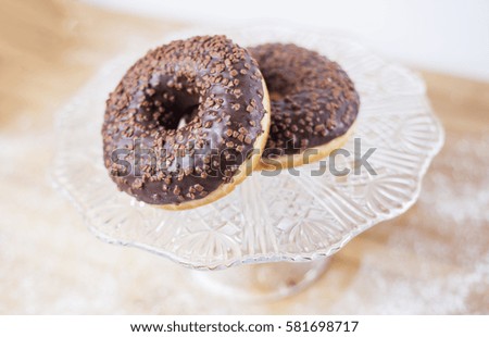 Chocolate donuts on glass plate.