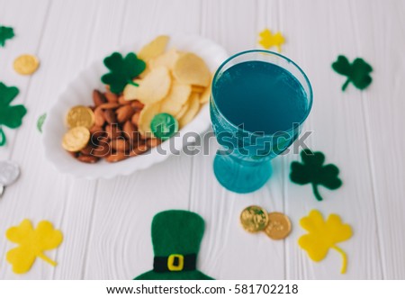 Traditional Irish St. Patrick's Day symbols hat, beer,clover leafs and coins on wooden background
