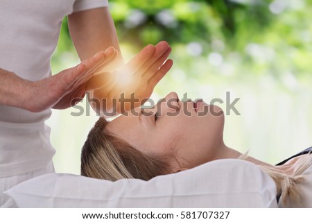 Woman having reiki healing treatment , alternative medicine, holistic care concept. Royalty-Free Stock Photo #581707327