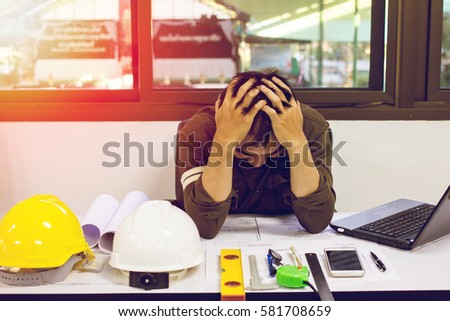 The man of designer sitting stress with work on the table and sunset background Royalty-Free Stock Photo #581708659