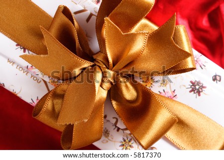 Gift box with a golden ribbon and bow.
