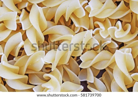 Fusilli dry pasta background concept. Pasta texture for background uses. Swirled pasta pattern. Food photography in studio.
