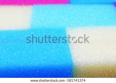 Cleaning kitchen sponge texture as background. Colorful yellow pink green purple blue multicolor sponges. Close up macro about sponges. Sponge pattern textures concept background or wallpaper 

