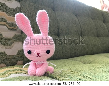 Pink bunny crochet doll in soft focus.