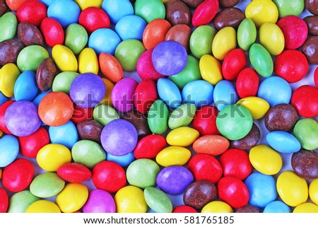 Shiny sugar coated round chocolate balls as background. Candy bonbons multicolored texture. Round candies sweets pattern concept. Smarties. Food photo studio photography. Candy background
