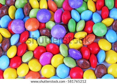 Shiny sugar coated round chocolate balls as background. Candy bonbons multicolored texture. Round candies sweets pattern concept. Smarties. Food photo studio photography. Candy background
