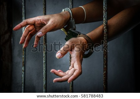 Prisoner in prison with handcuff Royalty-Free Stock Photo #581788483