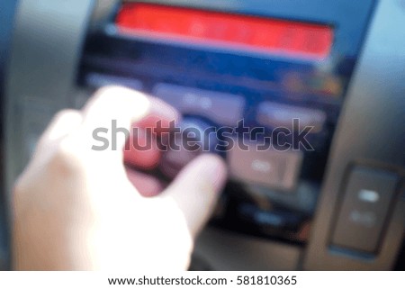 Picture blurred  for background abstract and can be illustration to article of hand adjusting the sound volume in the car stereo