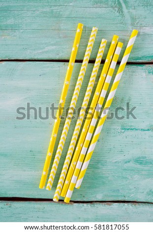 yellow striped paper straws on turquoise wooden background