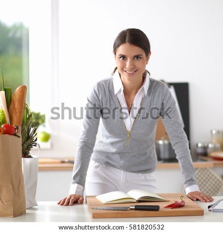 Woman making healthy food standing smiling in kitchen