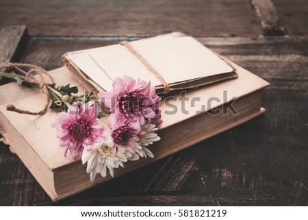 Vintage novel books with bouquet of flowers on old wood background - concept of nostalgic and remembrance in spring vintage background 