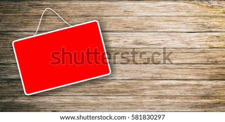 Red sign hanging on a wooden background