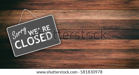 Sorry we are closed sign hanging on wooden background