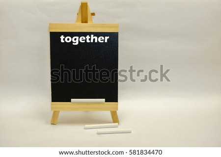 Small blackboard written "together" with white chalks isolated over white background