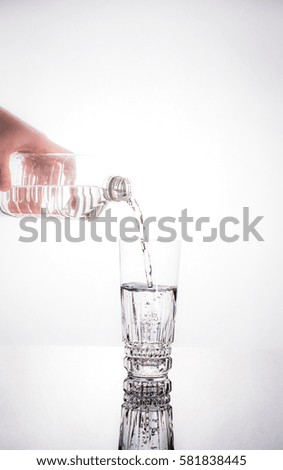 water pouring from the plastic water into the glass, healthy living concept