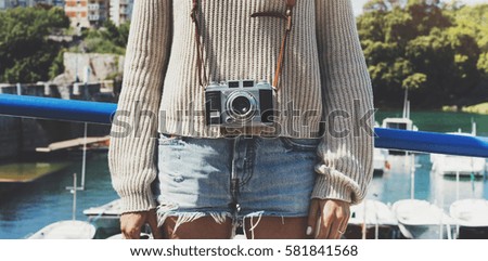 Tourist traveler photographer making pictures sea scape on vintage photo camera on background yacht and boat, hipster girl enjoying nature holiday, mock up ocean waves view, blurred backdrop