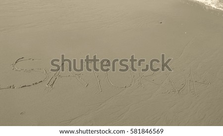 Handwriting words "SATURDAY" on sand of beach  