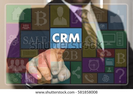 The businessman clicks the CRM button on the touch screen with metro style graphic user interface. 