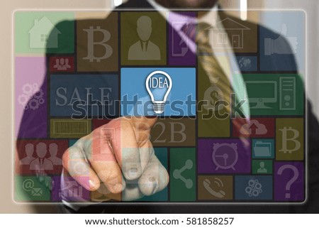 Businessman presses the button idea bulb icon on the touch screen with metro style graphic user interface. 