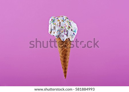 Ice cream in wafer cone on pink background