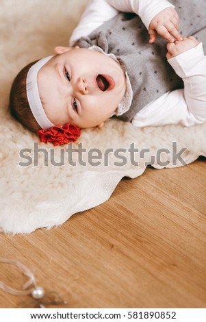 Portrait of a baby lying on a blanket of wool. close-up. baby yawns