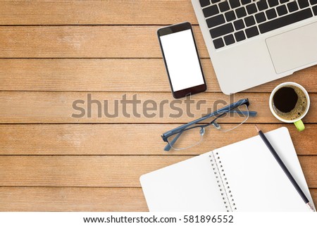 Laptop computer and smart phone with cup of coffee on wooden table. Top view with copy space for any design