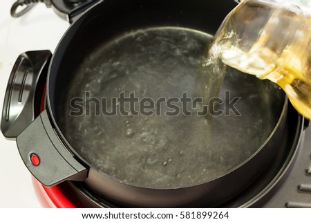 Pouring broth transparent to the electric pot