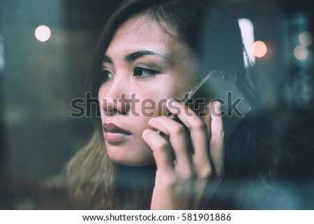 Young woman talking on mobile phone during rest in coffee shop.